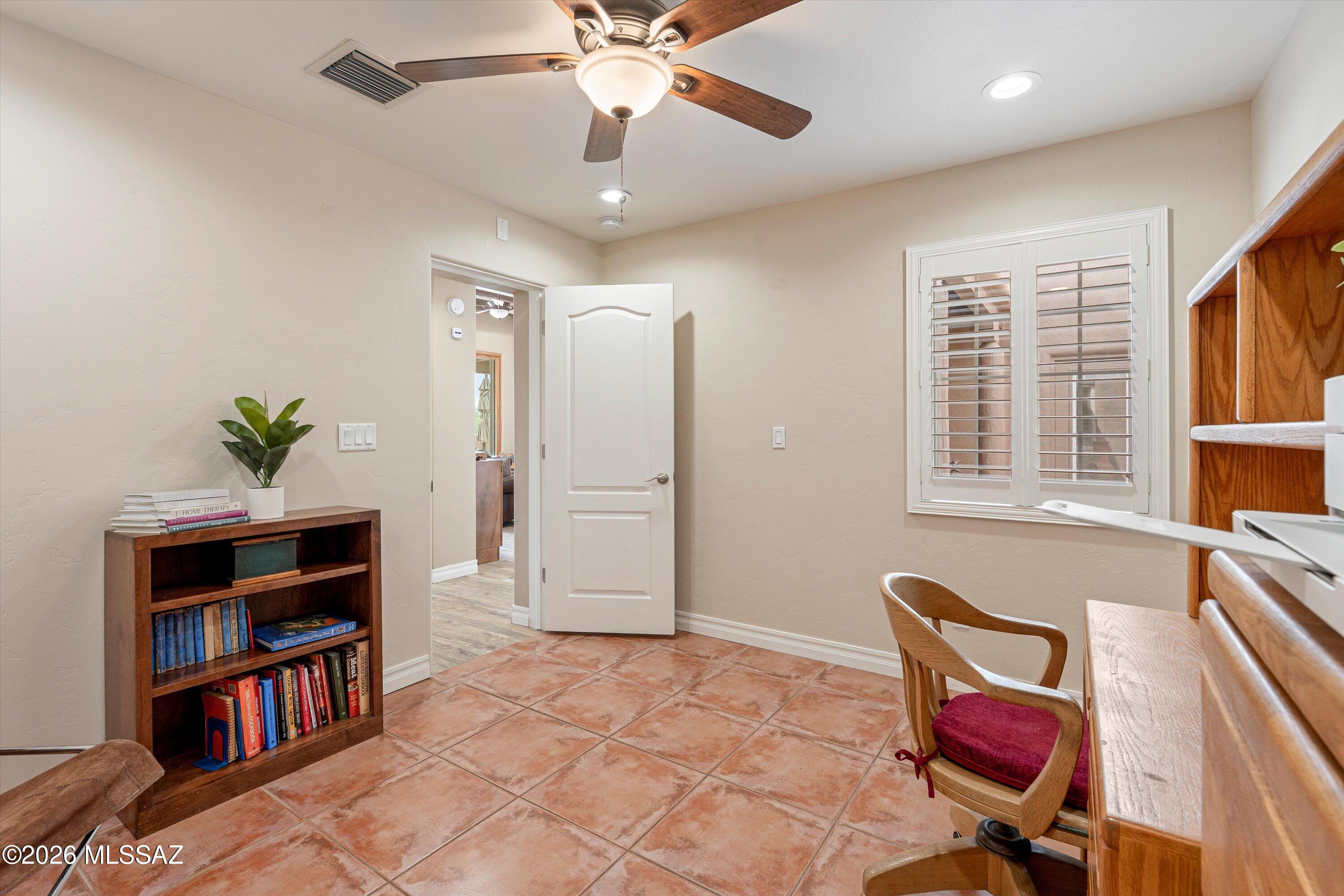 4760 East Wagon Train Road Tucson, AZ 85739 - Photo 24 of 38 a view of a workspace with furniture and a book shelf