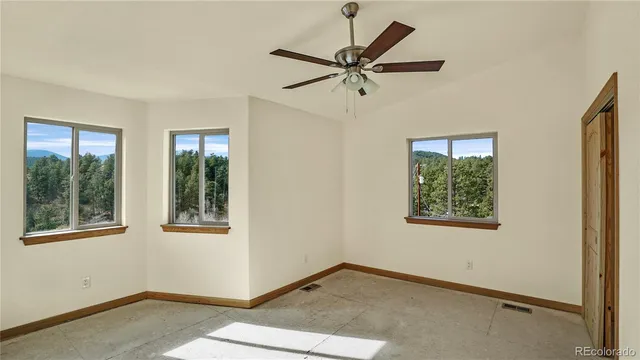 a view of a big room with wooden floor and windows