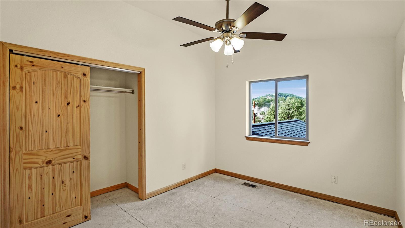 209 Fawn Road Bailey, CO 80421 - Photo 16 of 26 an empty room with windows and fan