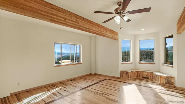 a bedroom with a bed ceiling fan and window