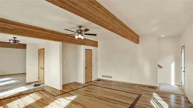 a view of a livingroom with wooden floor and bedroom
