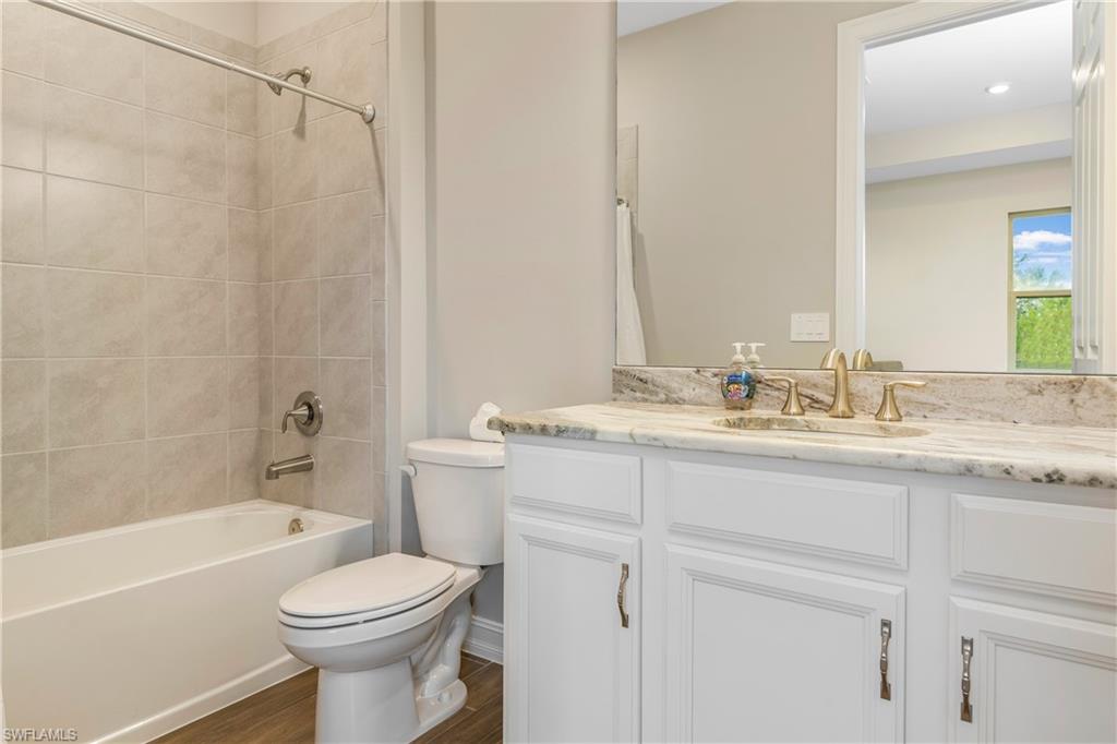 14586 Kelson Circle Naples, FL 34114 - Photo 26 of 35 a bathroom with a granite countertop sink a toilet and shower