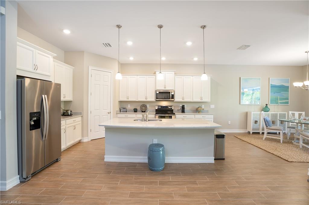 14586 Kelson Circle Naples, FL 34114 - Photo 7 of 35 a large kitchen with a table and chairs