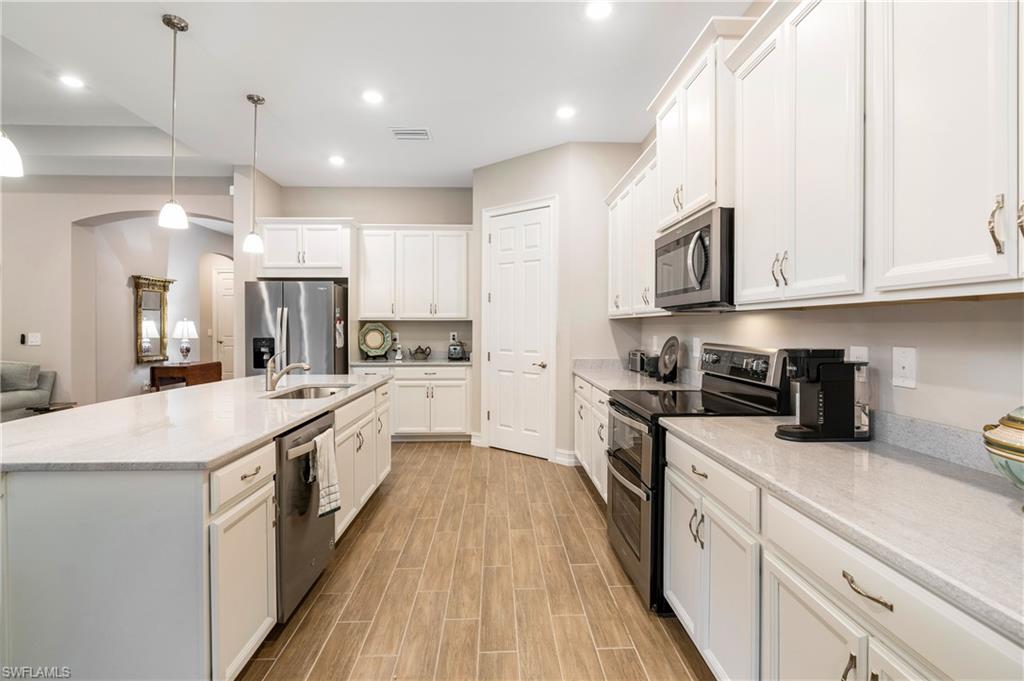 14586 Kelson Circle Naples, FL 34114 - Photo 8 of 35 a kitchen with stainless steel appliances granite countertop a sink and cabinets