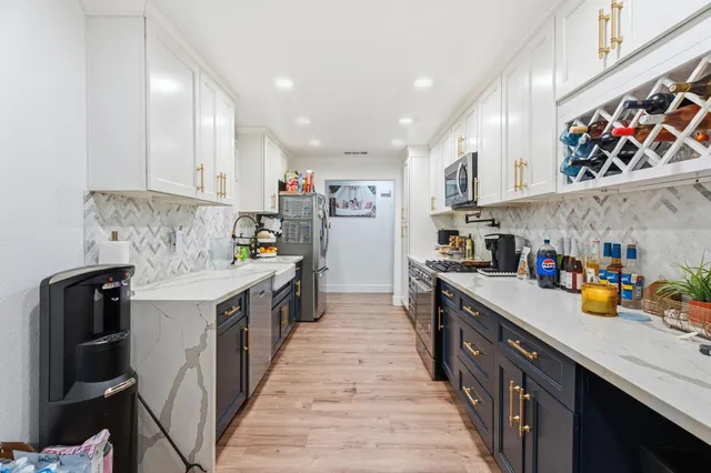 a kitchen with stainless steel appliances a sink stove top oven and cabinets