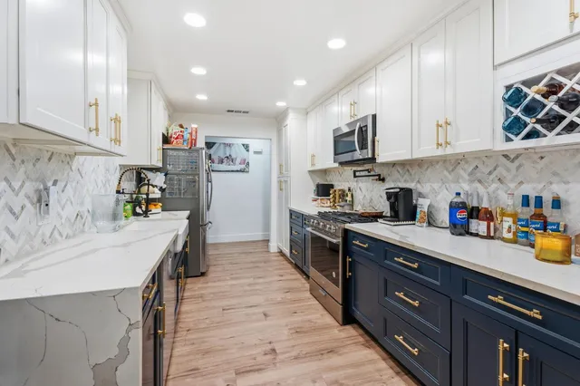 a kitchen with stainless steel appliances granite countertop a sink stove and refrigerator