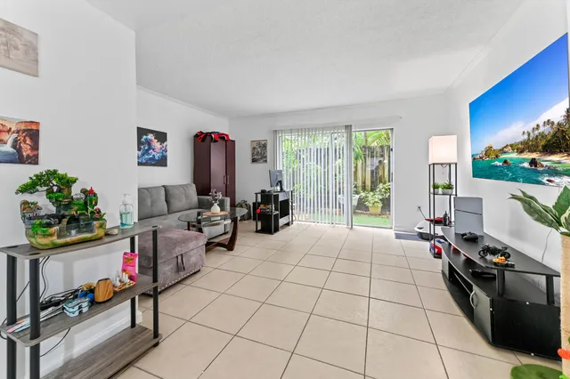 a living room with furniture a flat screen tv and a floor to ceiling window