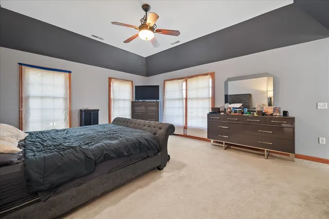 a spacious bedroom with a bed and a chandelier