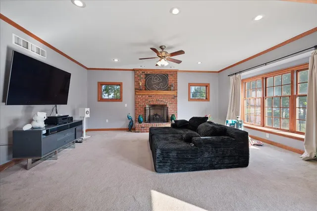 a living room with furniture a flat screen tv and a fireplace