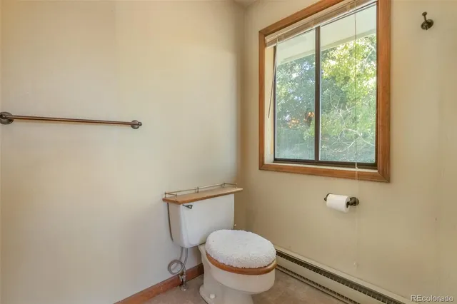 a bathroom with a toilet window and vanity