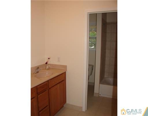 962 Clark Road North Brunswick, NJ 08902 - Photo 8 of 10 a bathroom with a granite countertop sink and a mirror