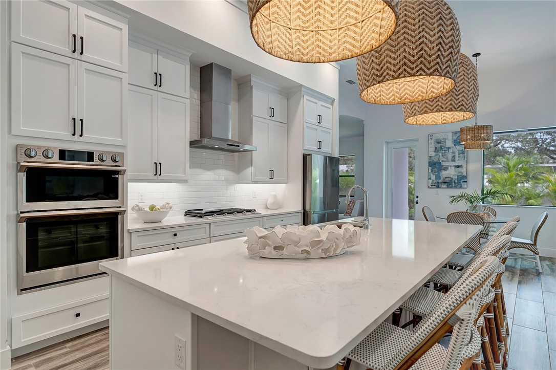 325 Holly Road Vero Beach, FL 32963 - Photo 10 of 25 a kitchen with stainless steel appliances a stove a table and chairs