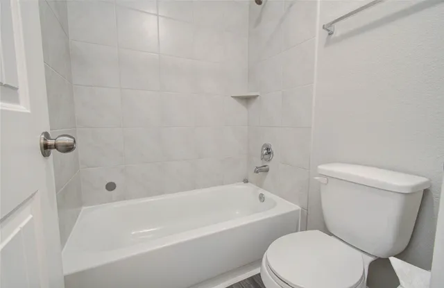 a white toilet and a bath tub sitting in a bathroom