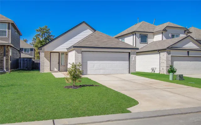 a front view of a house with a garden and yard
