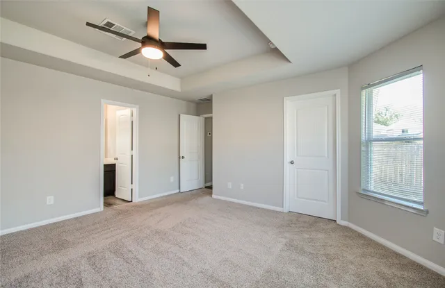 a view of a livingroom with a ceiling fan & windows