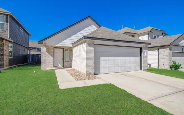 a front view of a house with a garden and yard