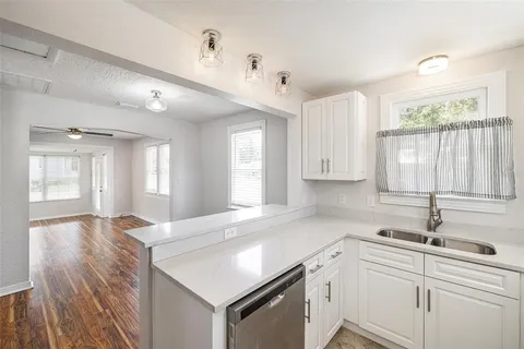 a kitchen with a sink window and cabinets