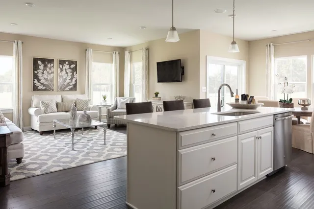 a living room with furniture a flat screen tv and a window