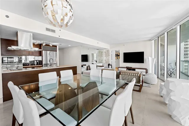 a living room with furniture kitchen view and a large window