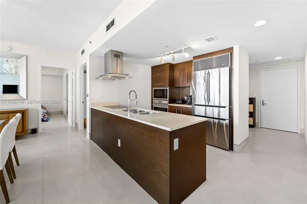 a kitchen with kitchen island a sink stove and refrigerator