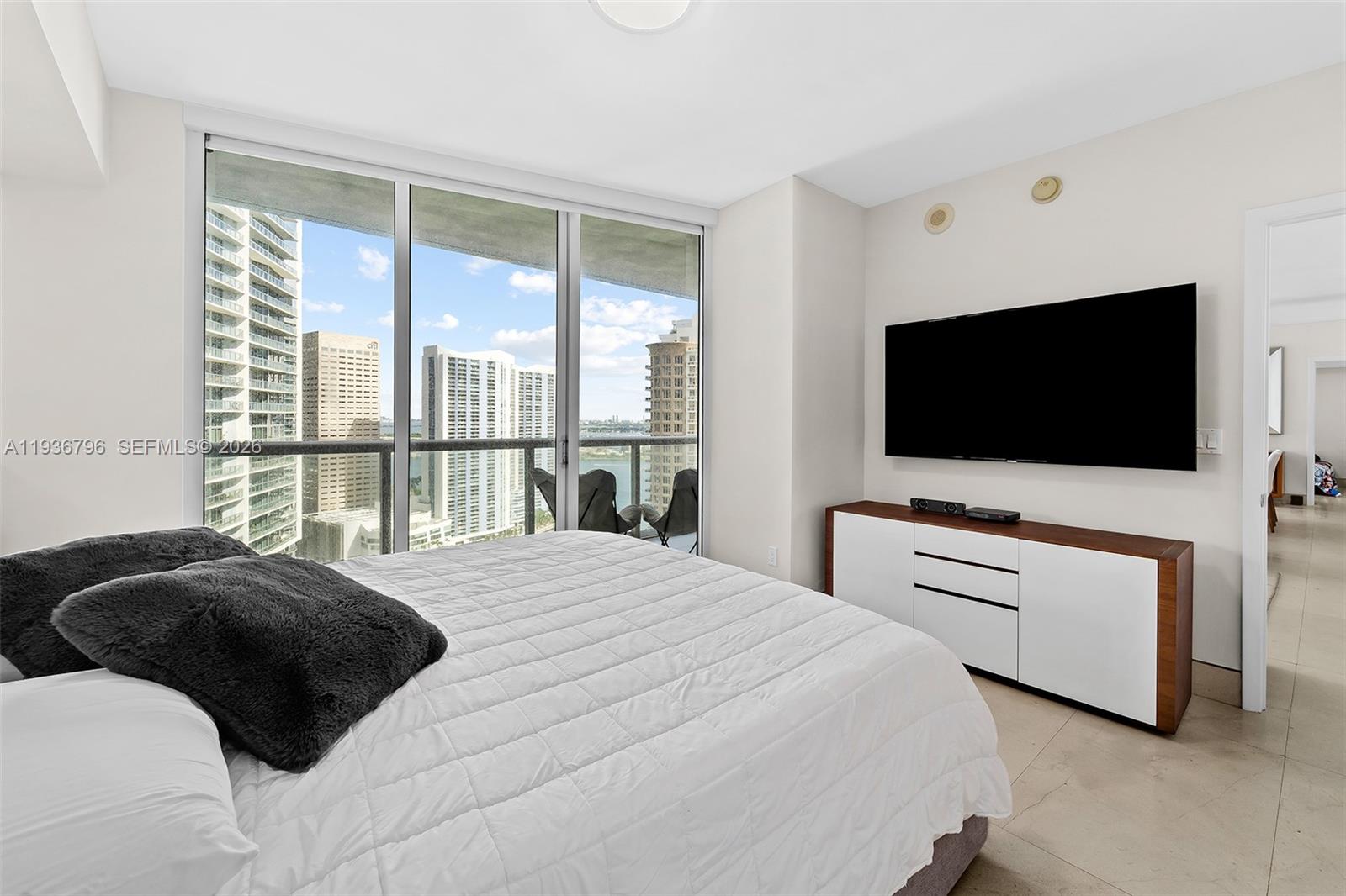 495 Brickell Avenue, Unit 2904 Miami, FL 33131 - Photo 13 of 29 a bedroom with a bed and a flat tv screen on dresser