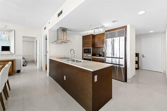 a kitchen with kitchen island a sink stove and refrigerator