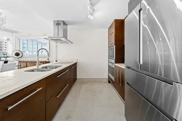a kitchen with stainless steel appliances a sink and a refrigerator