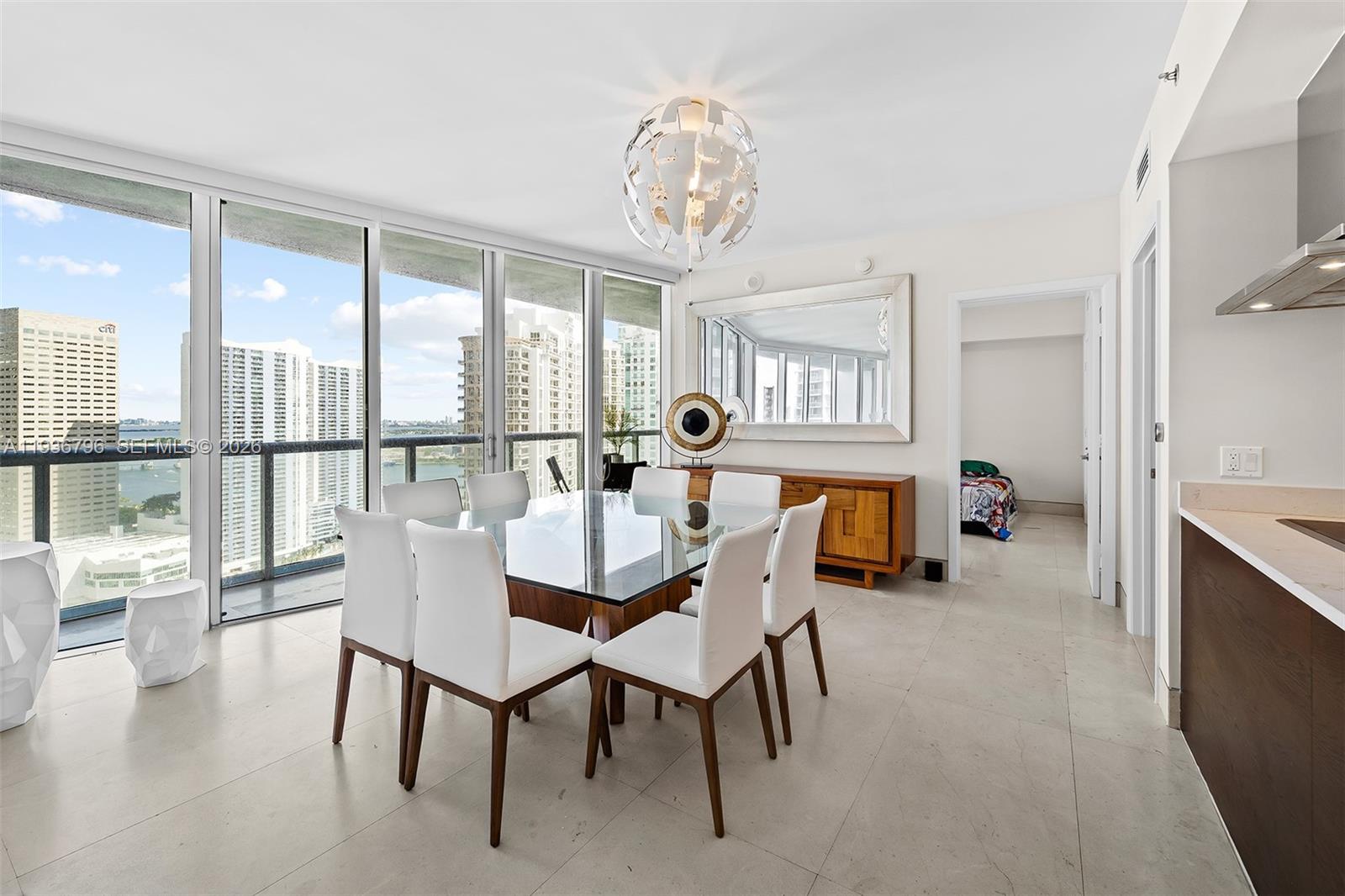 495 Brickell Avenue, Unit 2904 Miami, FL 33131 - Photo 7 of 29 a view of a dining room with furniture a chandelier and wooden floor