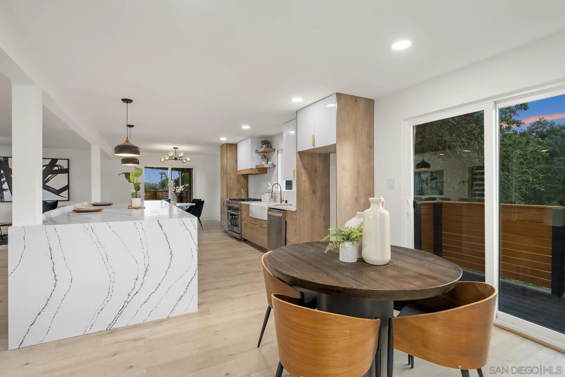 11442 Pinehurst Drive Lakeside, CA 92040 - Photo 12 of 46 a kitchen with stainless steel appliances kitchen island granite countertop a refrigerator a stove a dining table and chairs with wooden floor