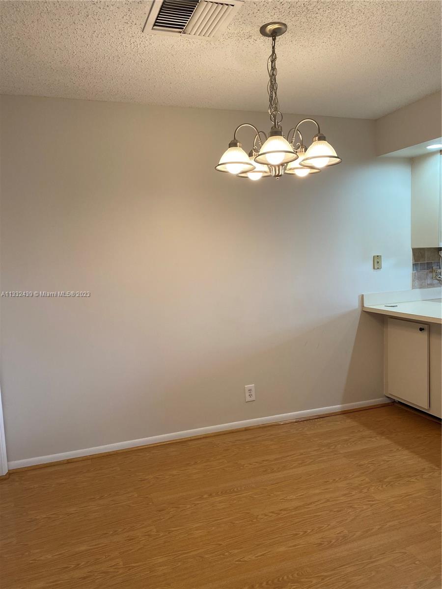 7657 Courtyard Run West, Unit 7657 Boca Raton, FL 33433 - Photo 18 of 36 a view of an empty room with a chandelier fan