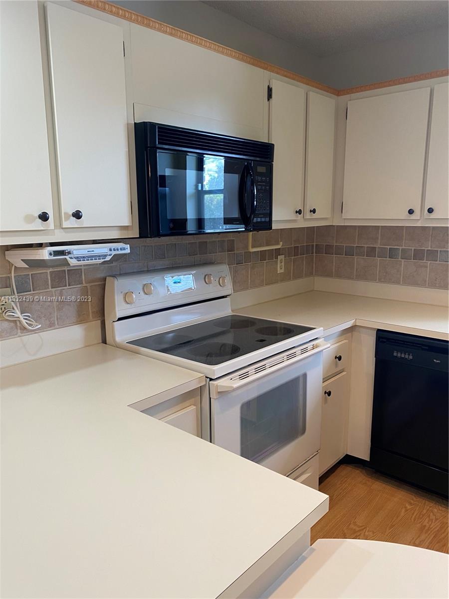7657 Courtyard Run West, Unit 7657 Boca Raton, FL 33433 - Photo 19 of 36 a kitchen with stainless steel appliances granite countertop a sink and a stove