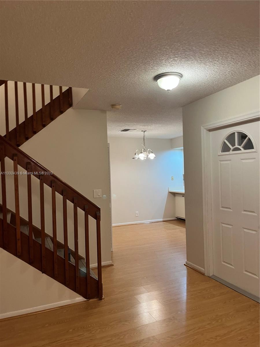 7657 Courtyard Run West, Unit 7657 Boca Raton, FL 33433 - Photo 21 of 36 a view of a hallway with wooden floor and stairs