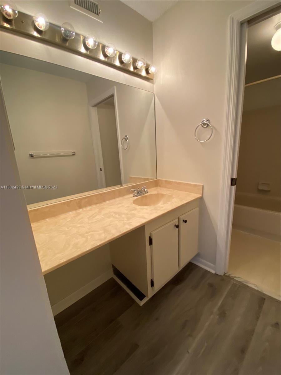 7657 Courtyard Run West, Unit 7657 Boca Raton, FL 33433 - Photo 29 of 36 a bathroom with a sink and mirror