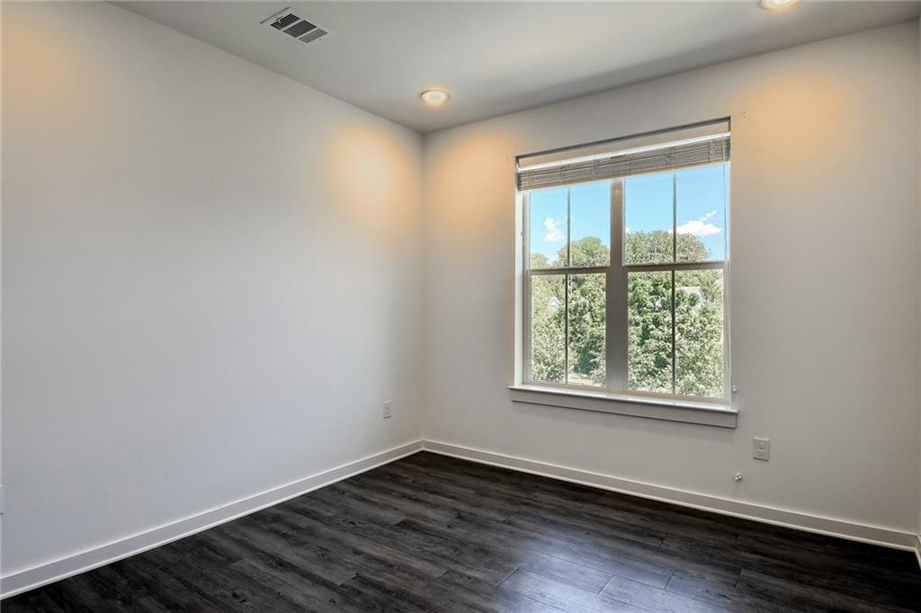 2624 Metcalfe Road, Unit 7 Austin, TX 78741 - Photo 20 of 31 Wood-finish flooring with white baseboards, recessed lighting, and a large window with white trim