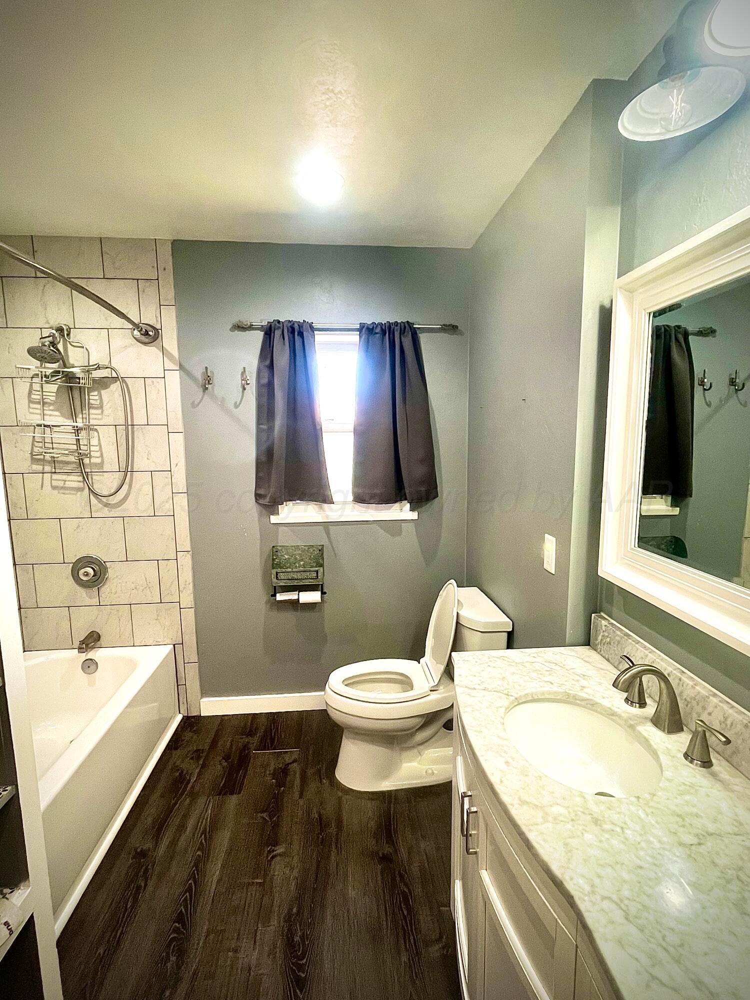 5116 Crockett Street Amarillo, TX 79110 - Photo 11 of 23 a bathroom with a sink and a mirror