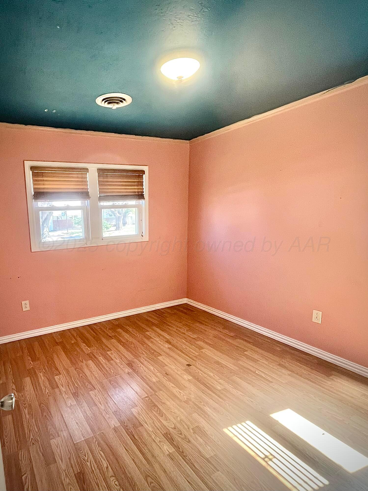 5116 Crockett Street Amarillo, TX 79110 - Photo 14 of 23 an empty room with wooden floor and windows
