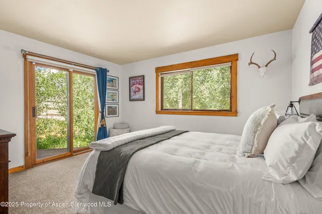 a bedroom with a bed and a large window