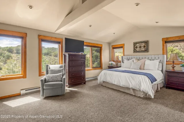 a spacious bedroom with a bed couch and window