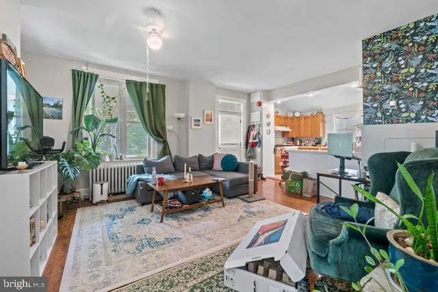 a living room with furniture a large window and a table