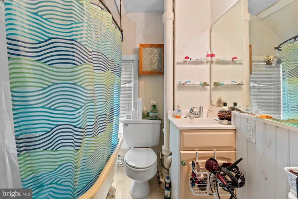 a bathroom with a sink a toilet and a shower curtain