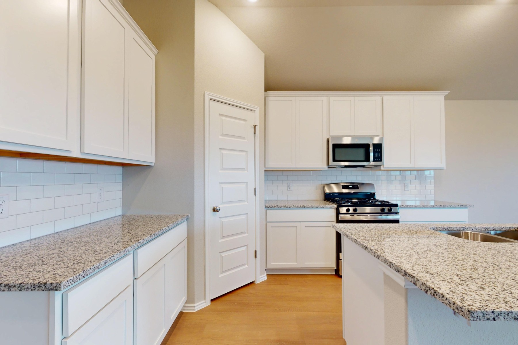 20017 Schatz Way Manor, TX 78653 - Photo 4 of 34 a kitchen with stainless steel appliances granite countertop a sink stove and microwave