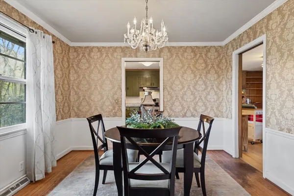 a view of a dining room with furniture and chandelier