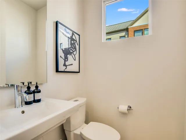 a bathroom with a toilet a sink and mirror