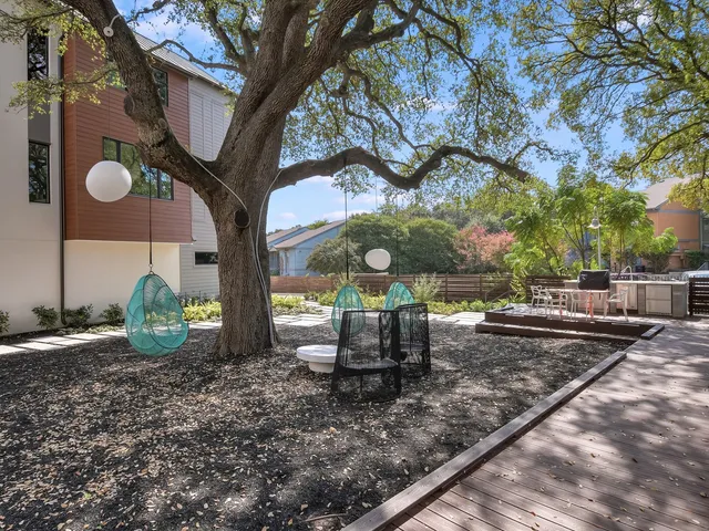 a view of a backyard with garden and tall trees