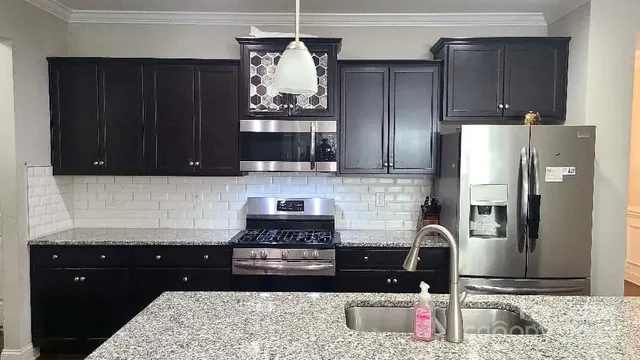 a kitchen with granite countertop stainless steel appliances and wooden cabinets