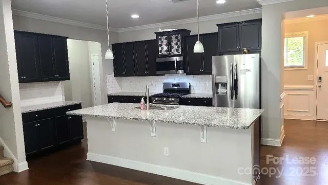 a large kitchen with a center island stainless steel appliances and cabinets