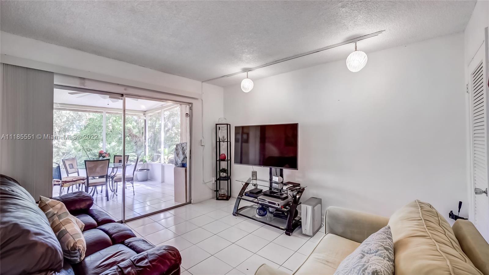 14107 Southwest 66th Street, Unit D7 Miami, FL 33183 - Photo 11 of 38 a living room with furniture and a flat screen tv