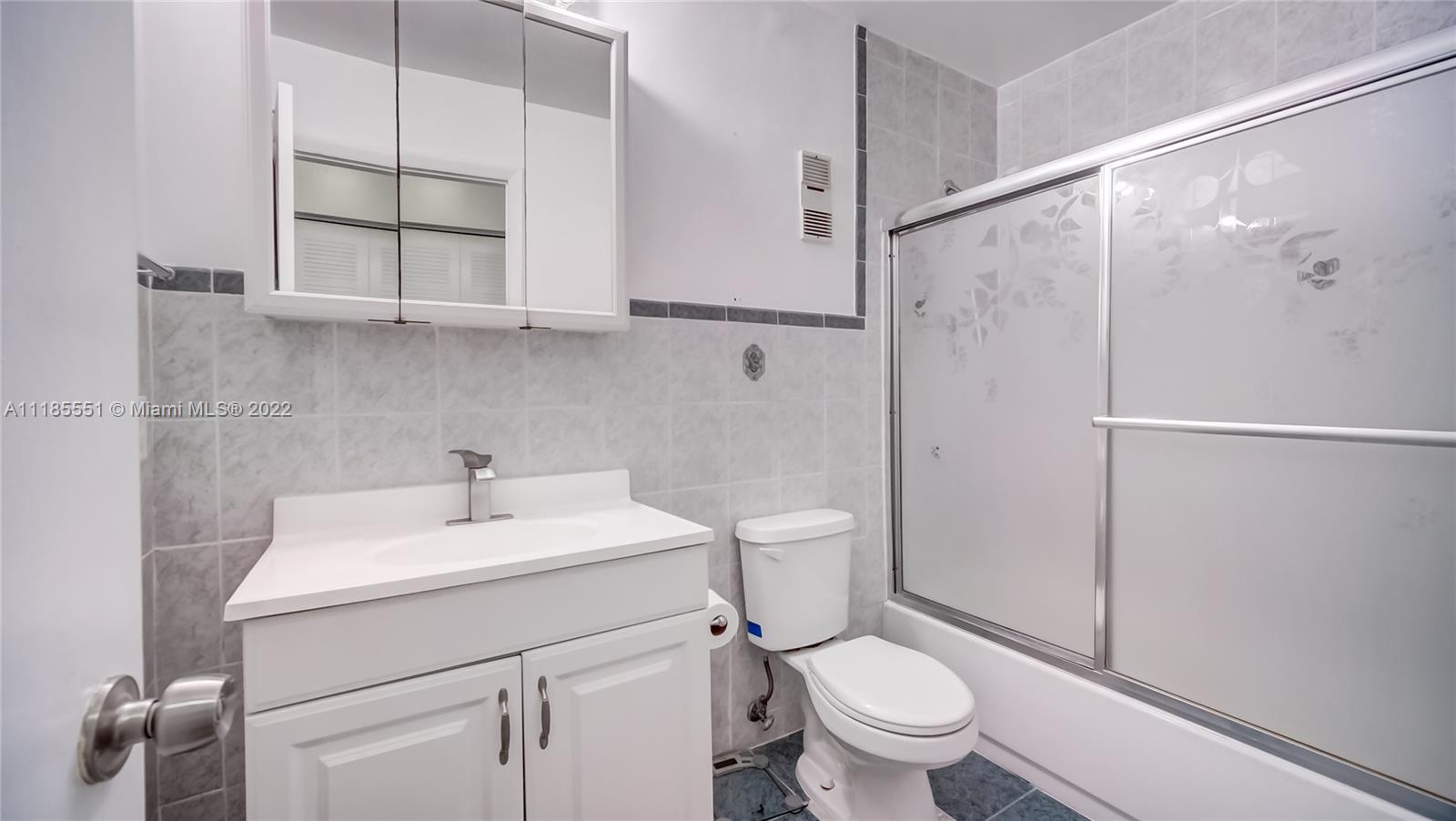 14107 Southwest 66th Street, Unit D7 Miami, FL 33183 - Photo 23 of 38 a bathroom with a sink a toilet and shower