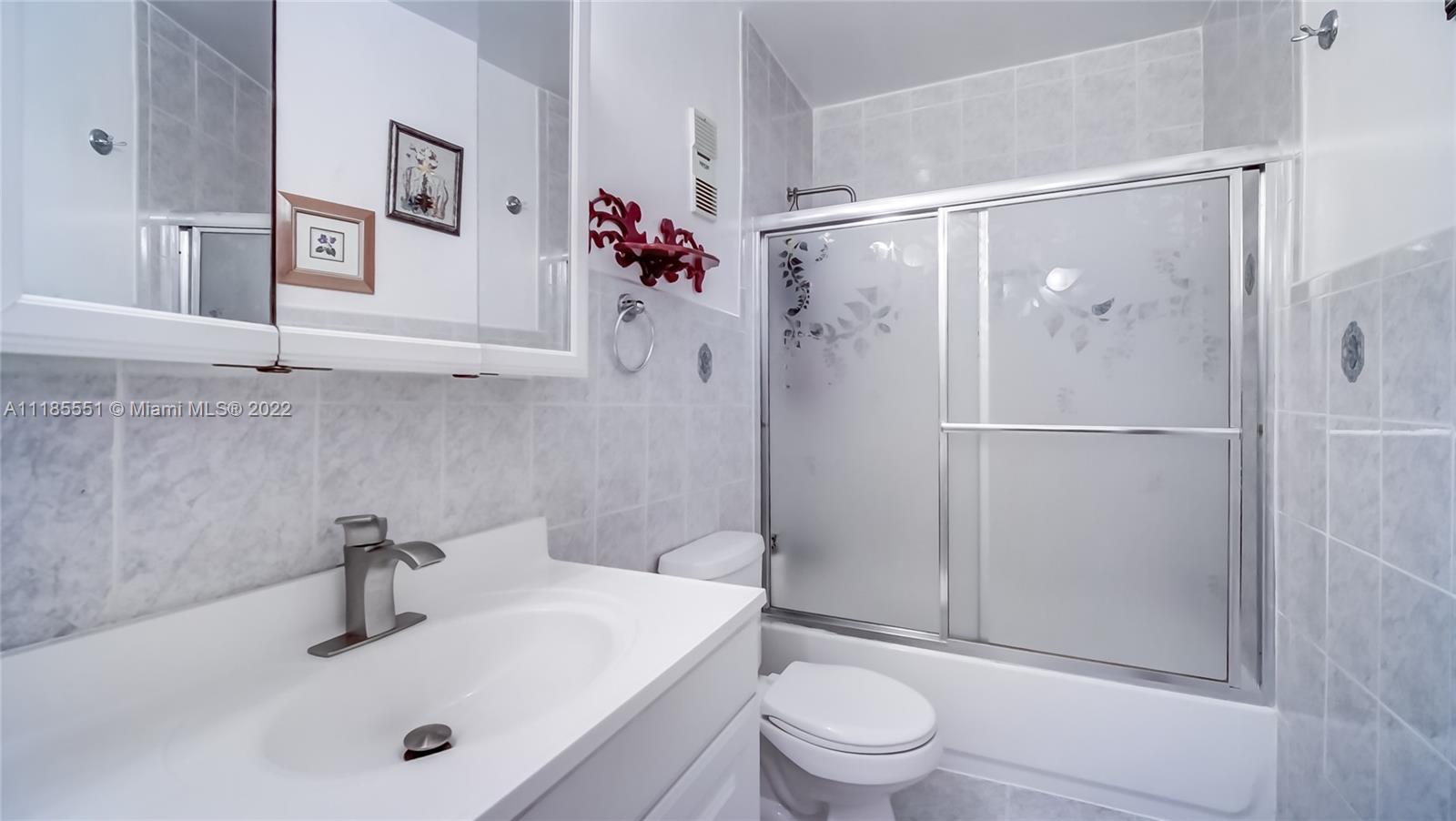14107 Southwest 66th Street, Unit D7 Miami, FL 33183 - Photo 26 of 38 a bathroom with a shower sink vanity mirror and toilet