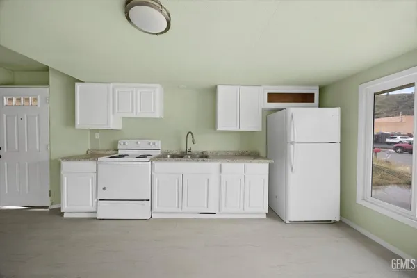 a kitchen with cabinets and a refrigerator